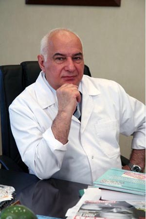 Ağ xalatlı mütəxəssis iş masası arxasında